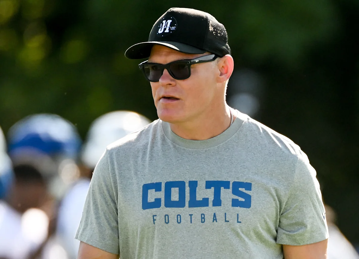 Man in sunglasses and black cap wearing a gray Indianapolis Colts football shirt outdoors