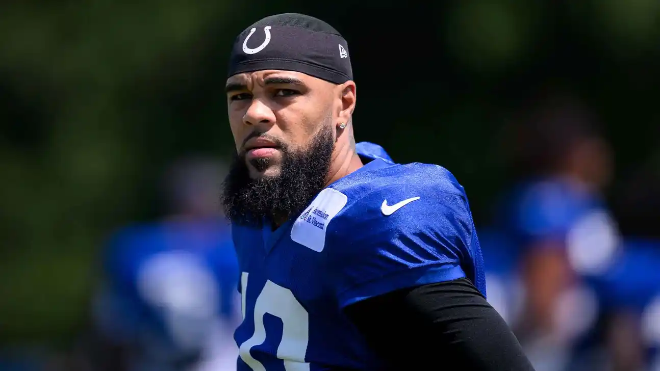 Football player in blue Colts jersey and black head covering standing on the field.