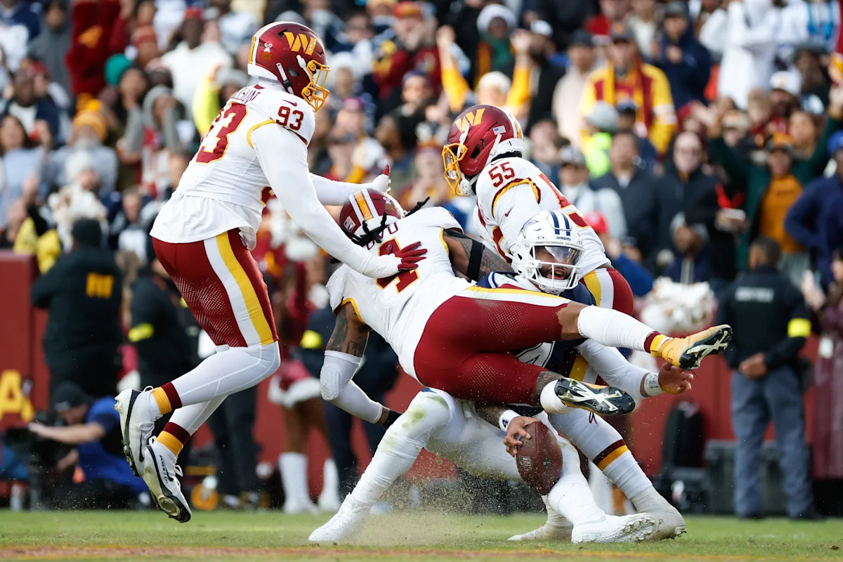 Washington players tackle an opposing ball carrier as the football slips loose