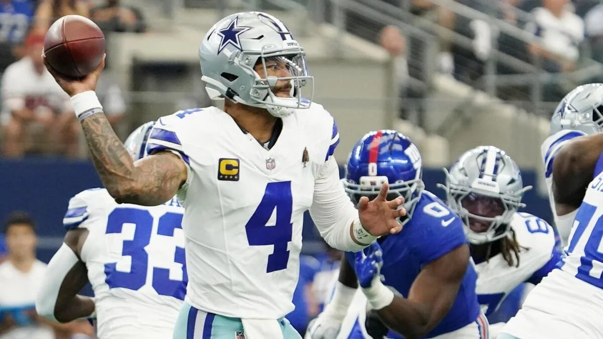 Cowboys quarterback throws a football as players converge during an NFL game