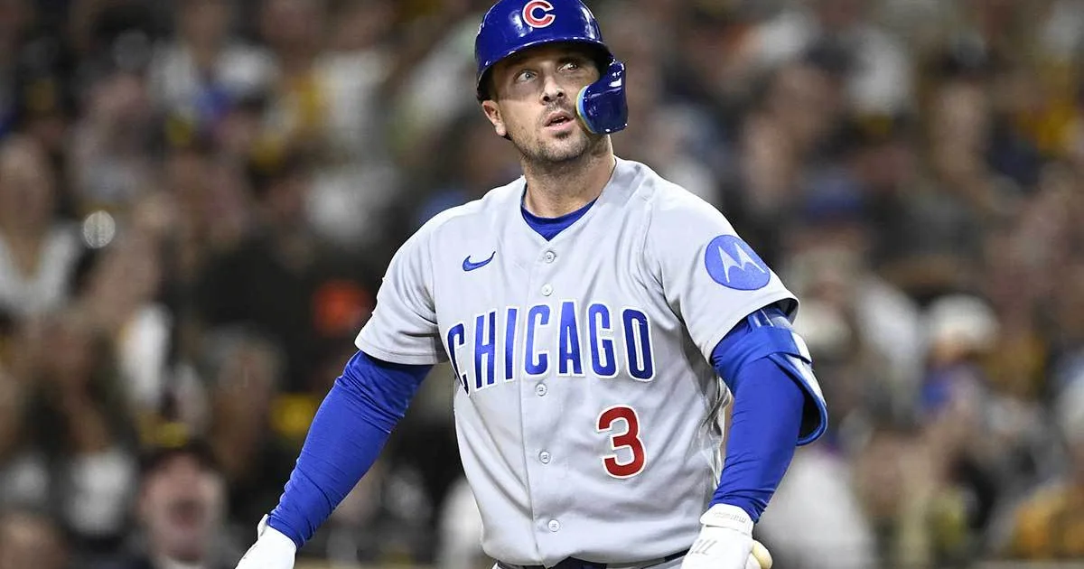 Chicago Cubs player in a gray uniform and blue helmet looks upward during a baseball game.