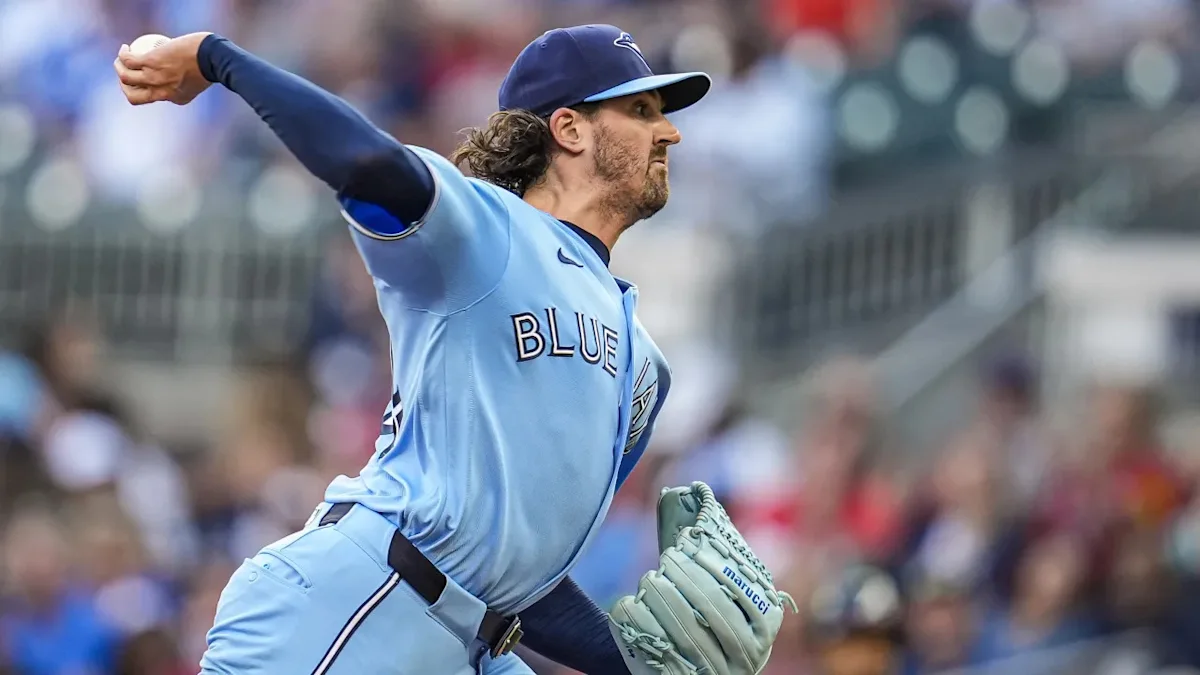 Baseball pitcher in blue uniform throwing a pitch during a game