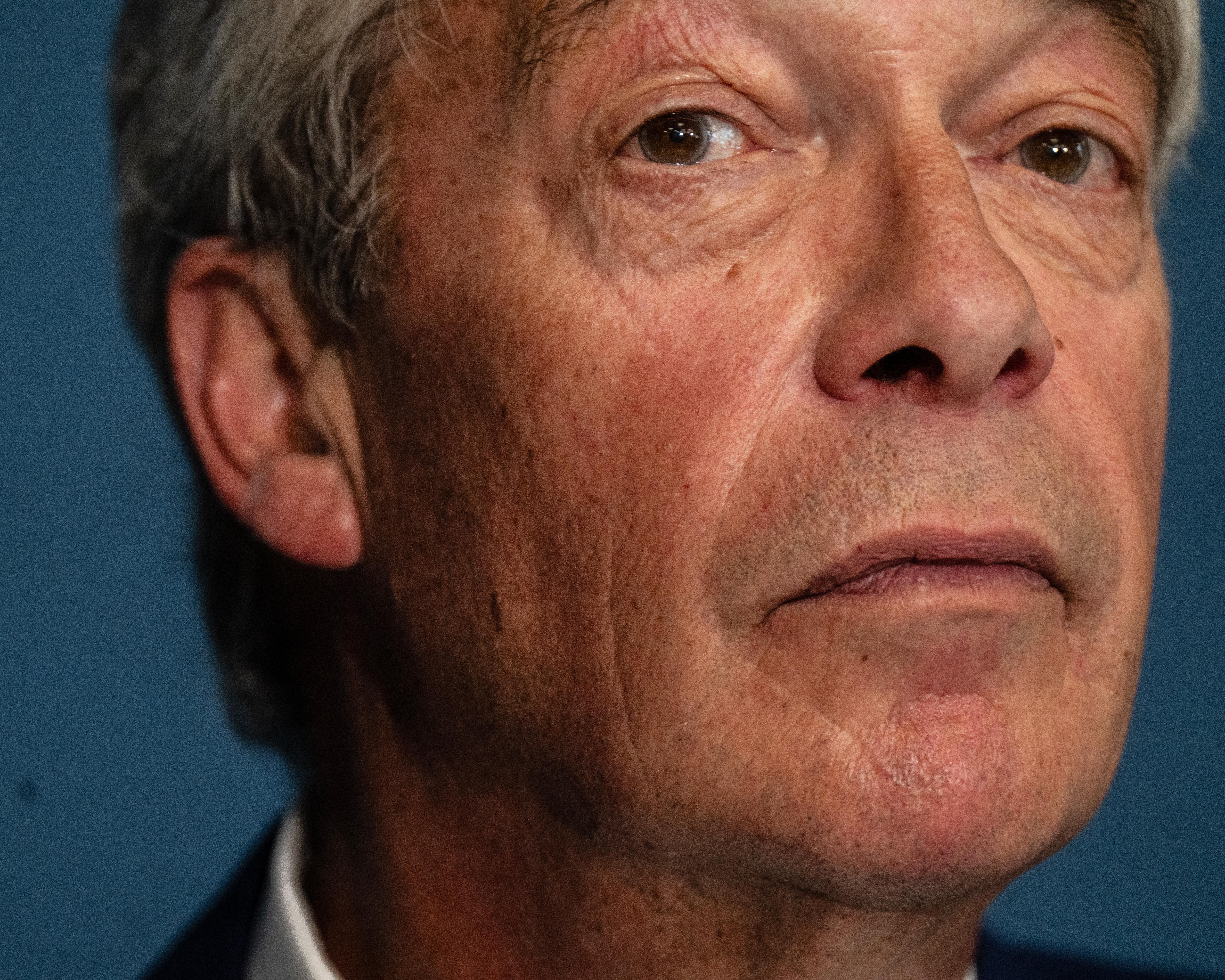 Close-up portrait of an older man with grey hair and a serious expression