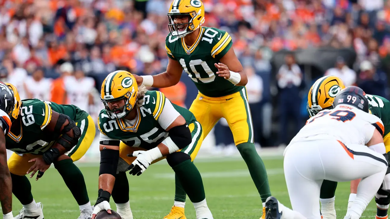 Green Bay quarterback lines up behind center against Denver defenders during an NFL game
