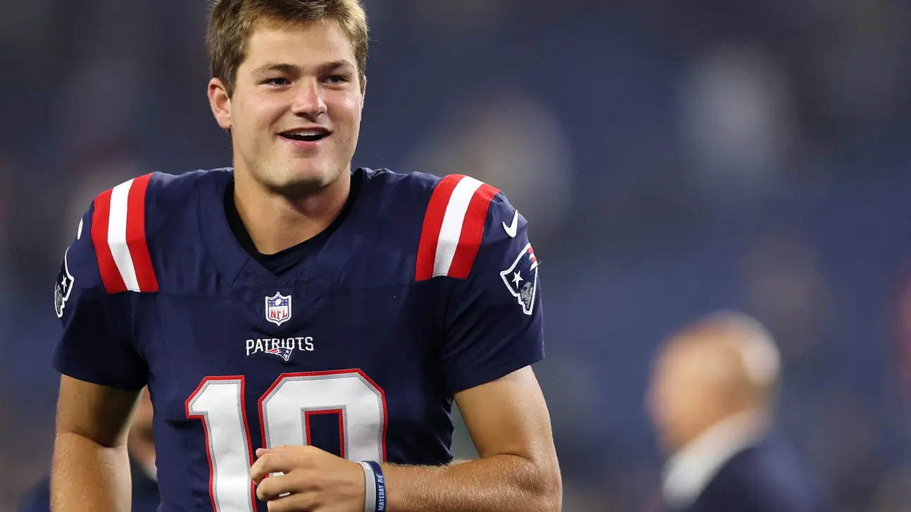 New England Patriots quarterback in uniform smiling during a football game