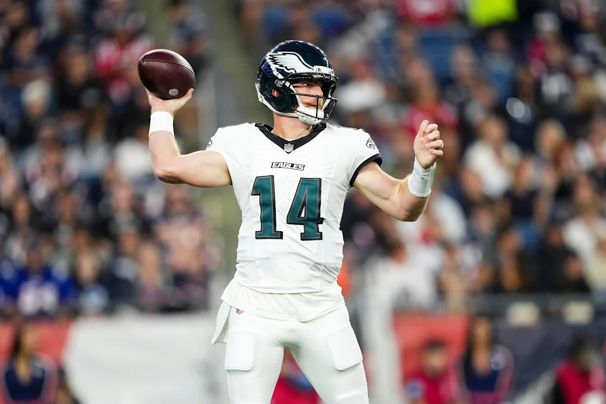 Philadelphia Eagles quarterback wearing No. 14 holds a football during a game.