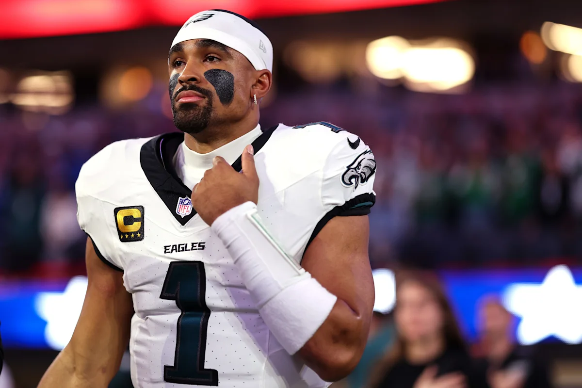 Philadelphia Eagles quarterback in white uniform and headband standing on the sideline during a game