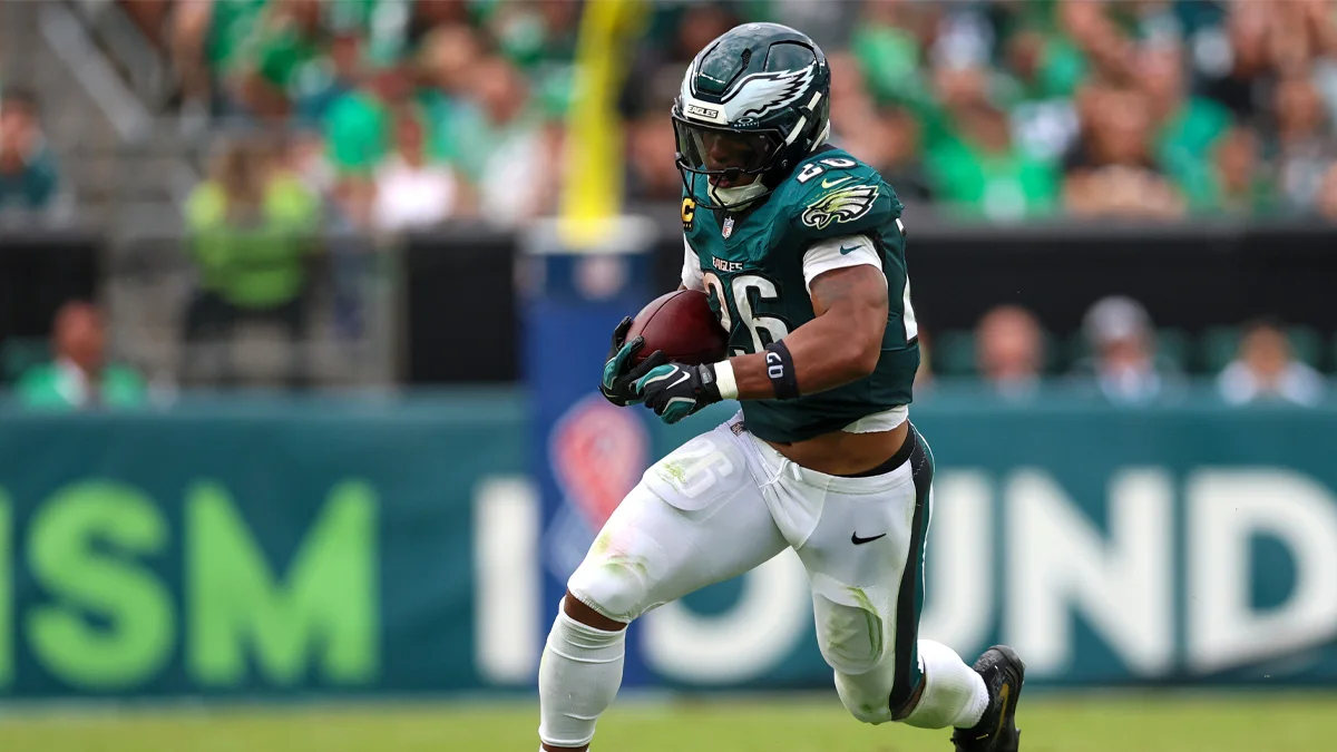 Philadelphia Eagles running back in uniform carries the football during a game.