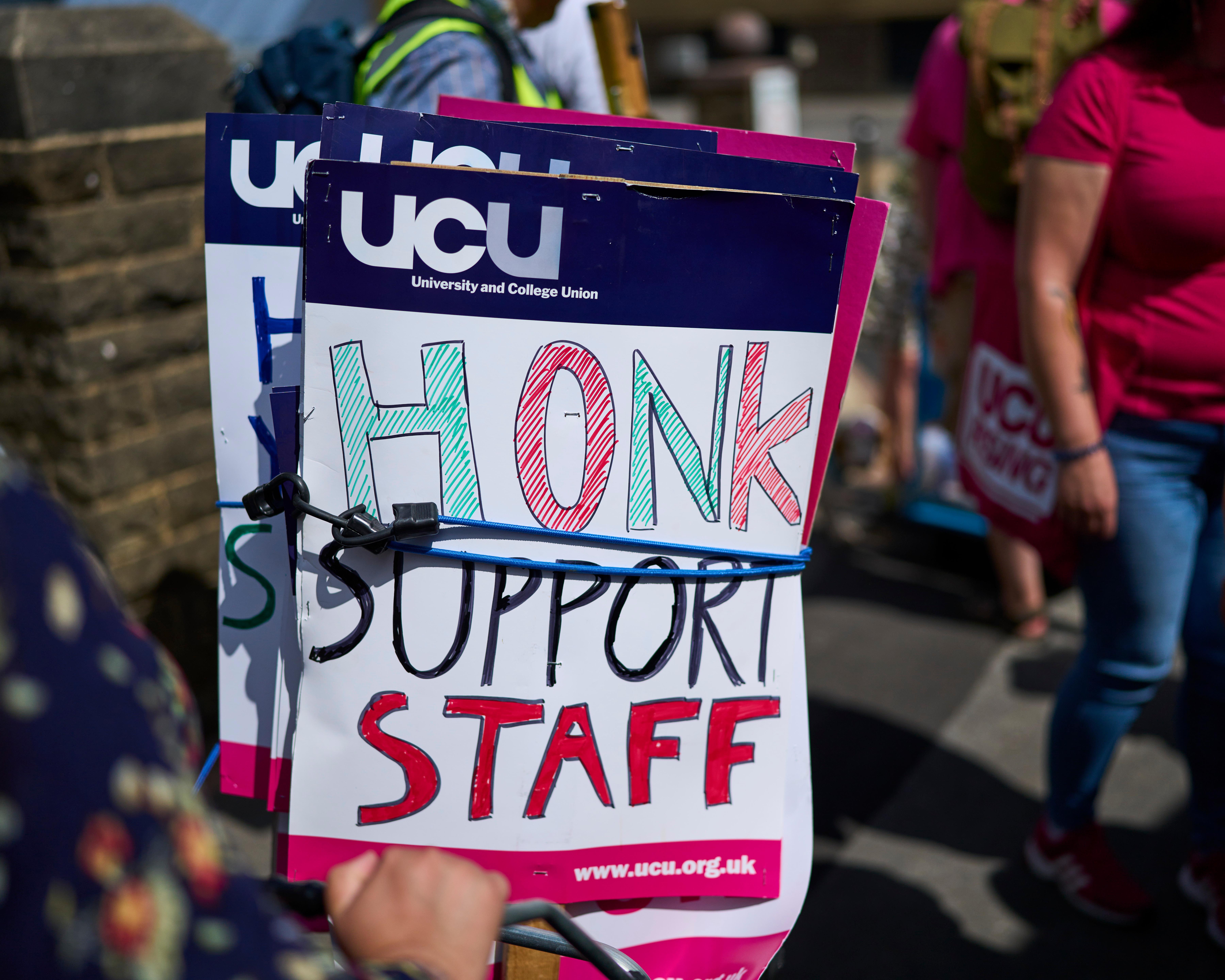 UCU placard reading “HONK SUPPORT STAFF” among people at an outdoor demonstration.