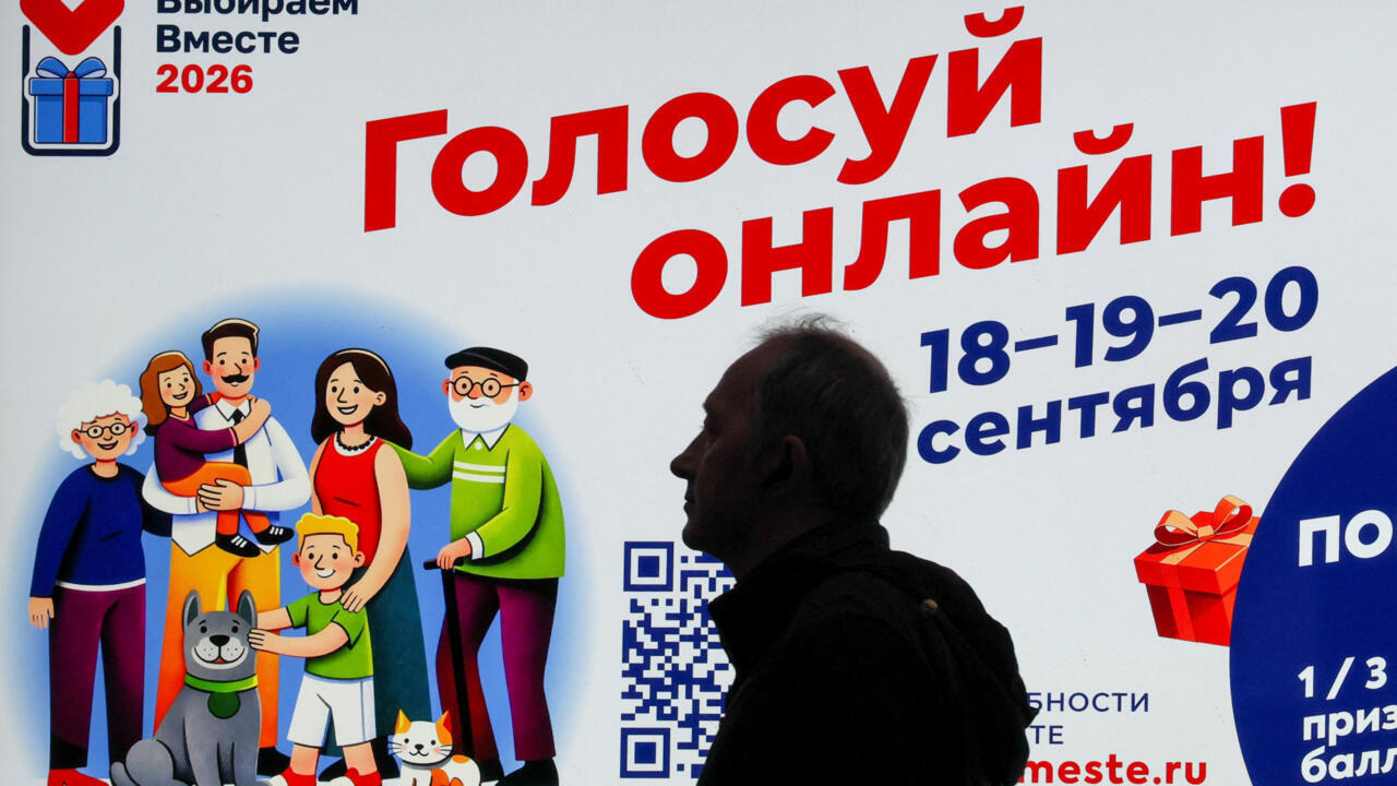 Silhouetted person stands before a Russian poster advertising online voting on September 18–20, 2026.