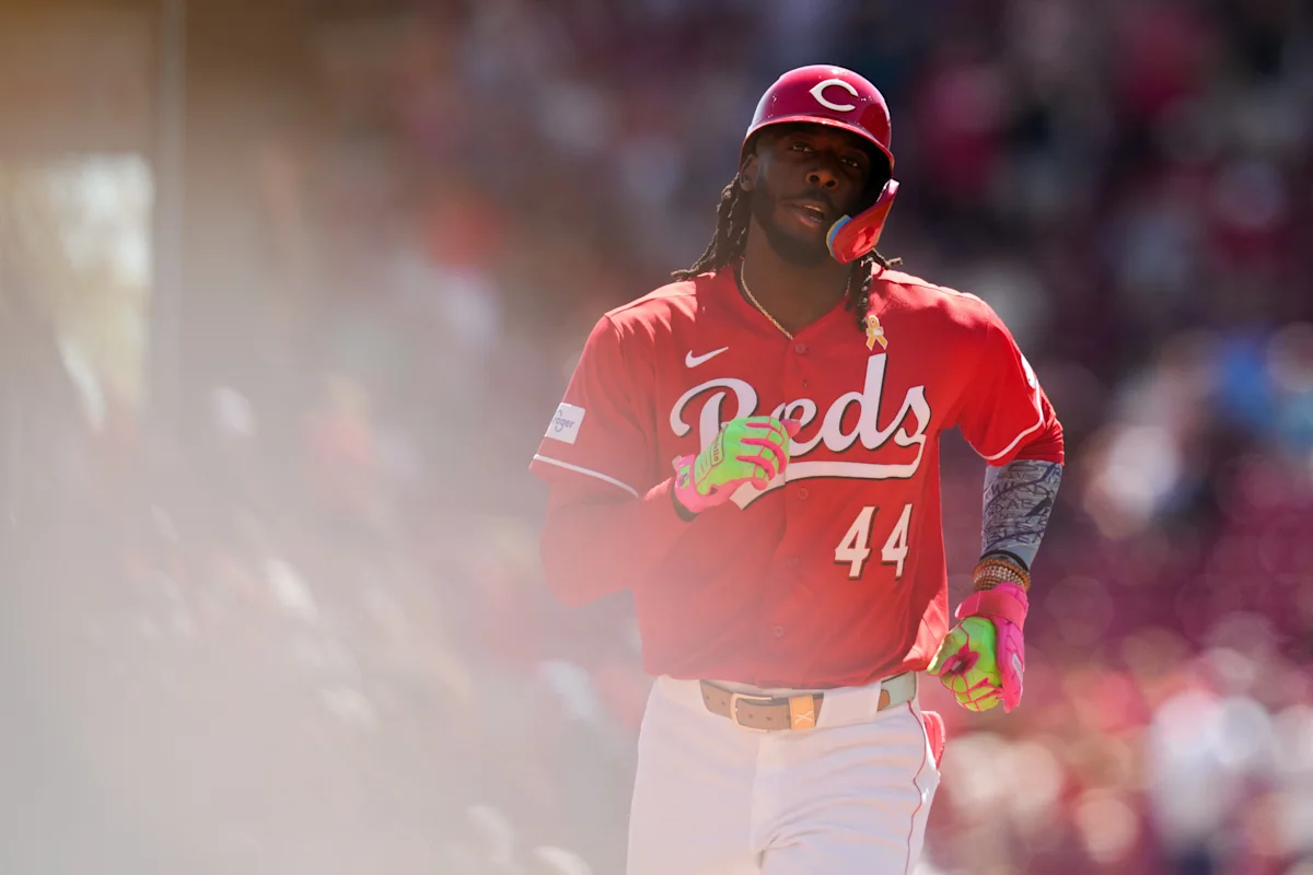 Cincinnati Reds baseball player wearing number 44 jersey and helmet while running on field