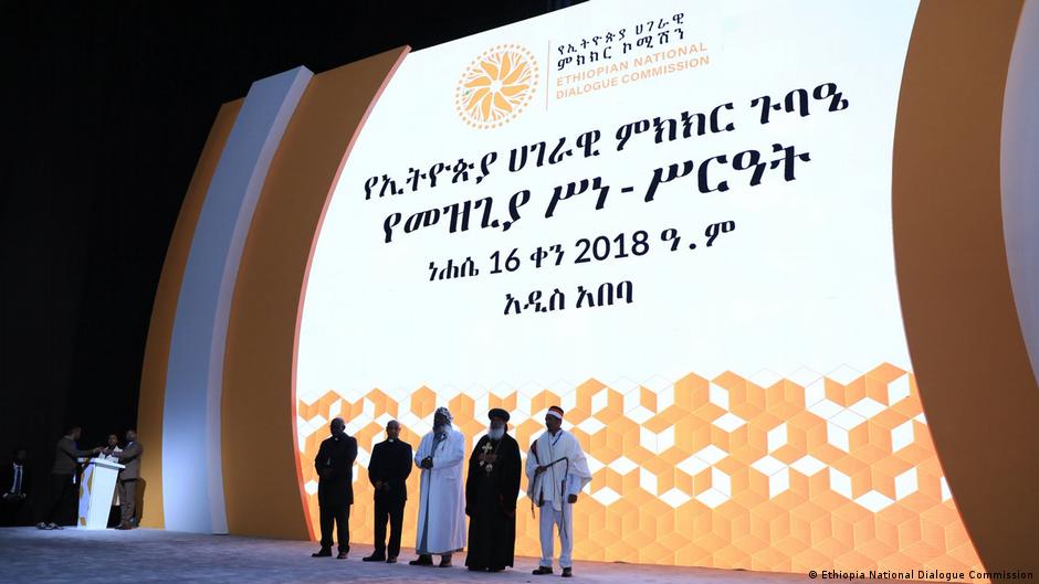 Ethiopian National Dialogue Commission event projected onstage as five people stand before the screen