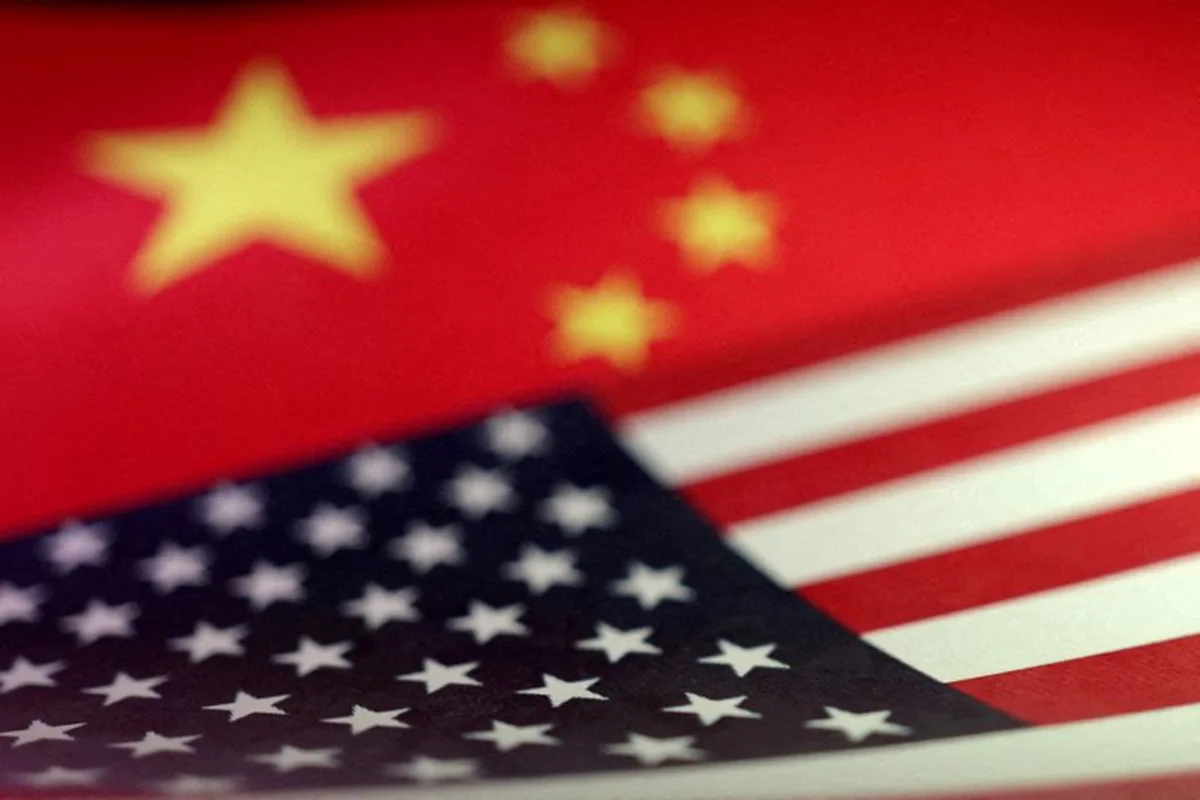 Close-up of Chinese and American flags overlapping, with stars and stripes softly out of focus.