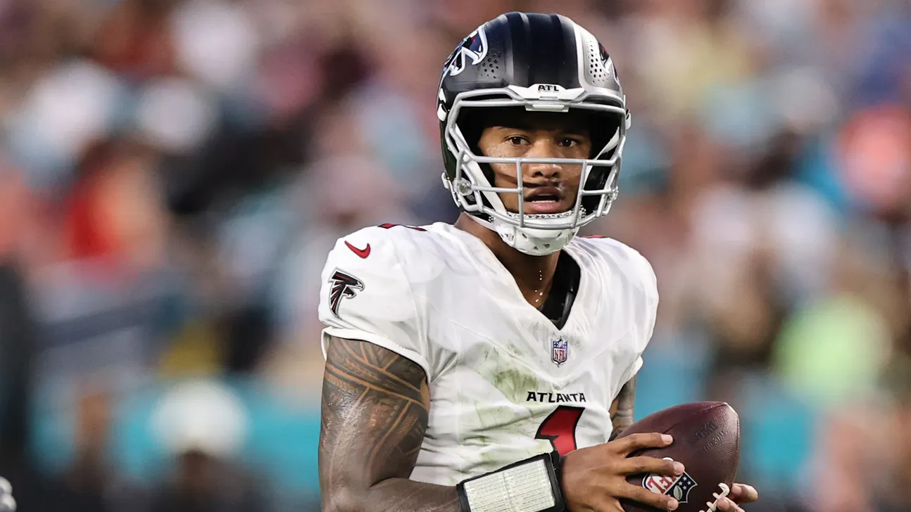 Atlanta Falcons quarterback in helmet and white uniform holds a football during a game