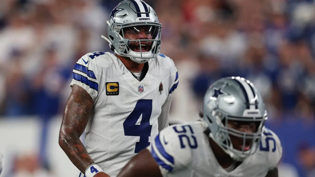 Dallas Cowboys football players in white uniforms celebrate during an NFL game.