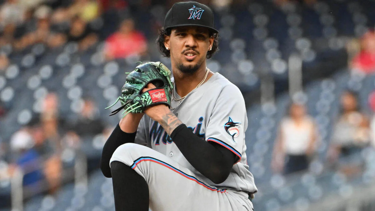 Miami Marlins pitcher raises his glove during a pitching motion in a stadium
