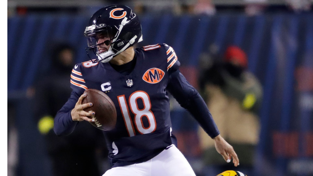 Chicago Bears quarterback wearing number 18 runs with the football during a game