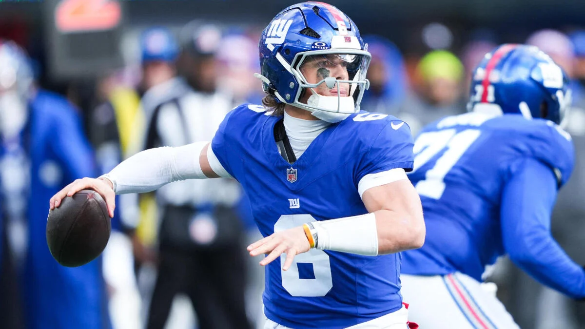Football quarterback in blue uniform holding a ball during a game