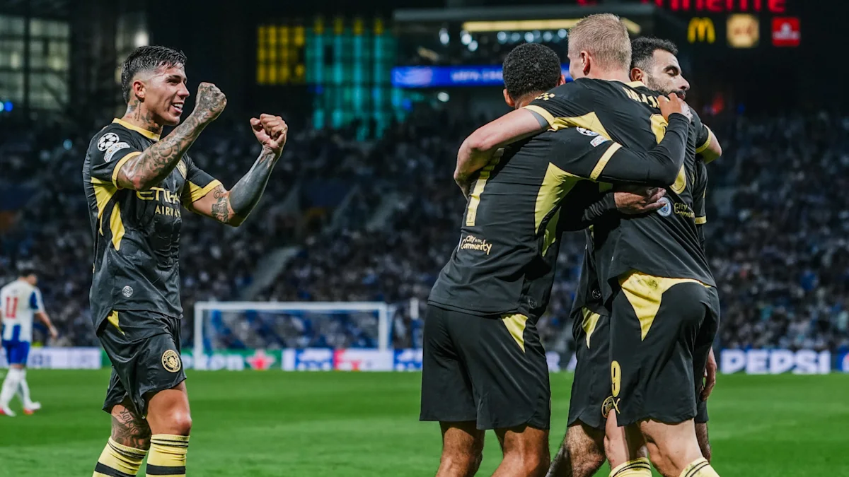 Football players in black and yellow kits celebrate together during a match.