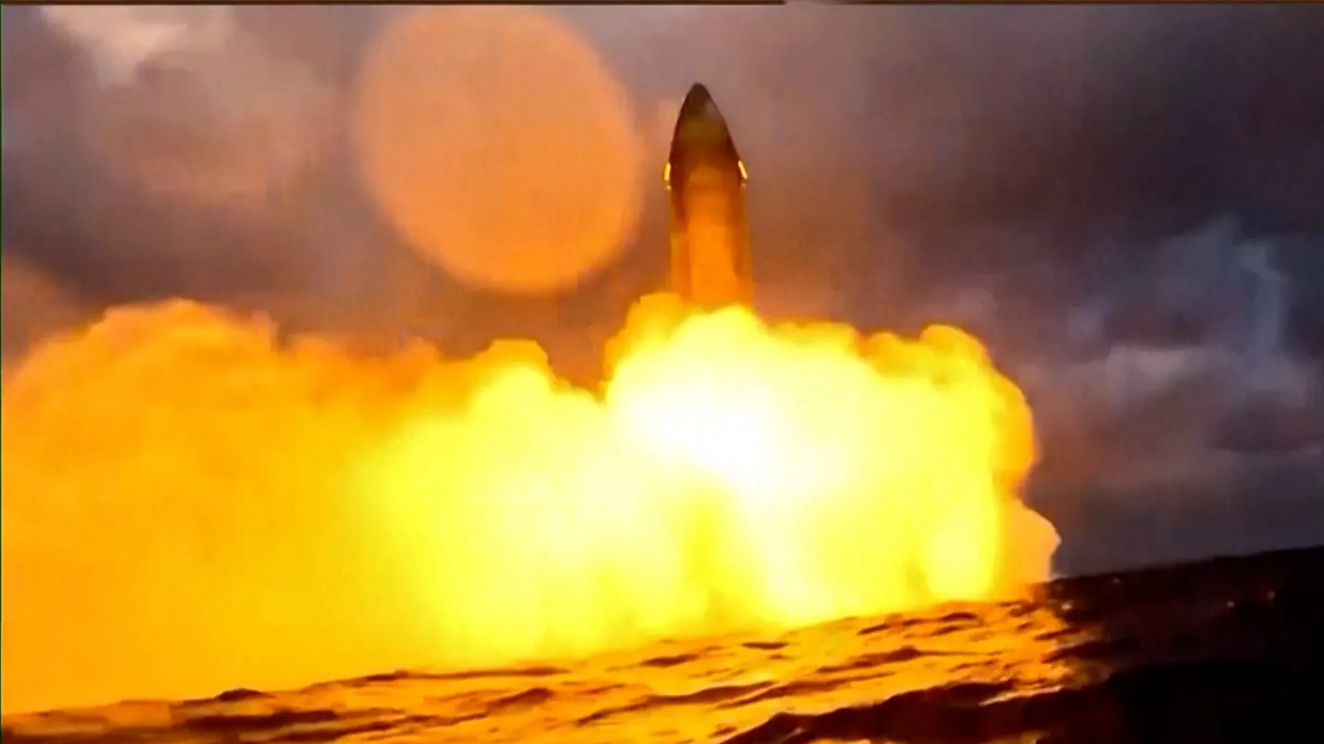 A rocket rises above a bright yellow-orange exhaust cloud against a dark, smoky sky.