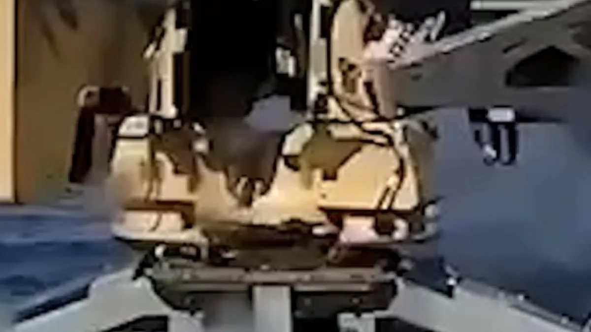 Blurry close-up of a small gray vessel carrying equipment on a body of water.