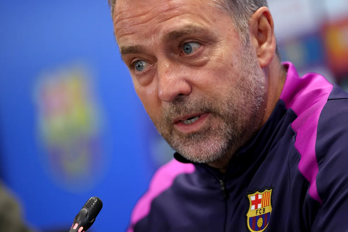 Close-up of a football coach speaking at a press conference in a Barcelona training jacket
