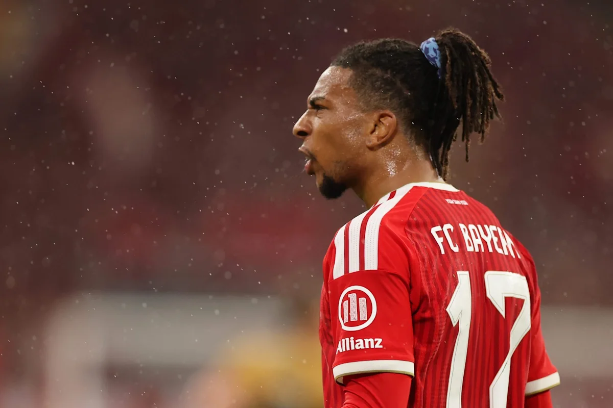 Footballer in a red Bayern Munich jersey with tied-back dreadlocks during a match