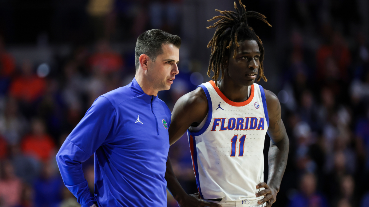 A Florida player in a white No. 11 jersey stands beside a coach in a blue pullover.