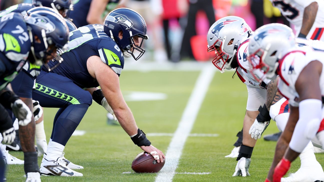 Seattle and New England football players line up across from each other before a snap.