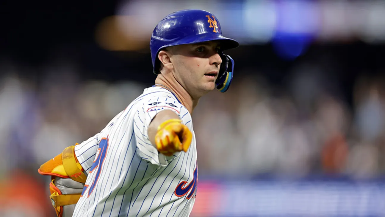 New York Mets batter in helmet and pinstriped uniform points toward the field.
