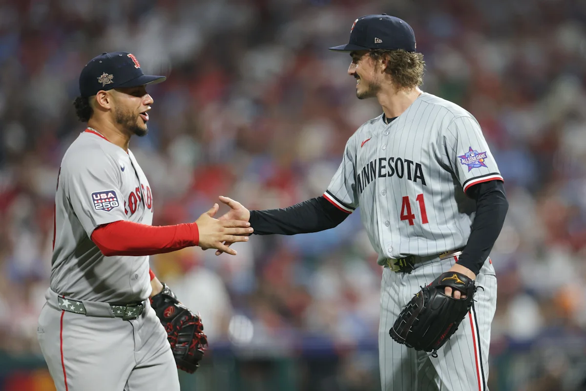 Baseball players in Minnesota Twins and Detroit Tigers uniforms shake hands on the field.