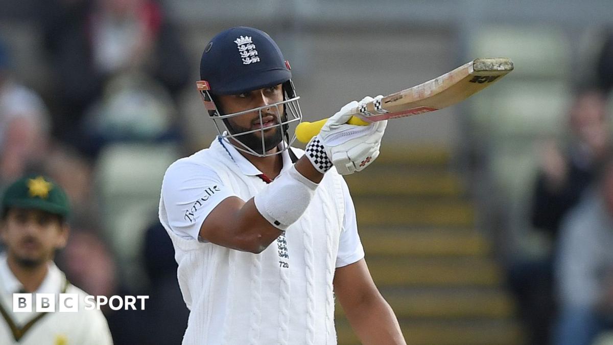 England batsman in helmet and whites raises his bat during play