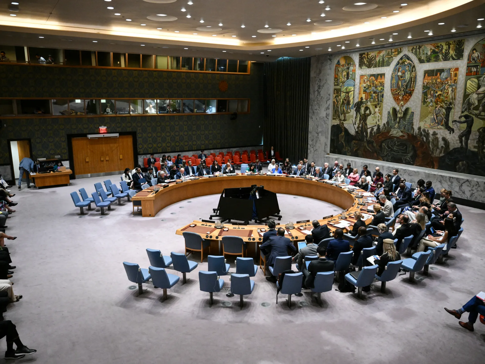 Delegates seated around the curved table inside a large Security Council chamber