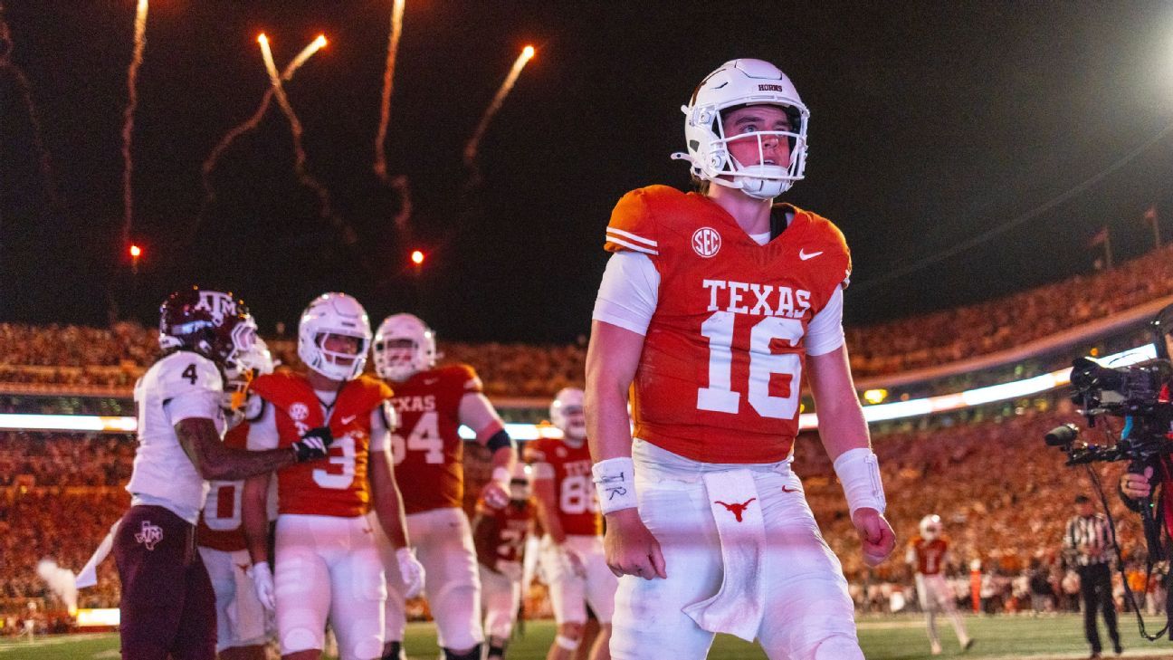 Football player in Texas uniform walks on field as fireworks rise above stadium.