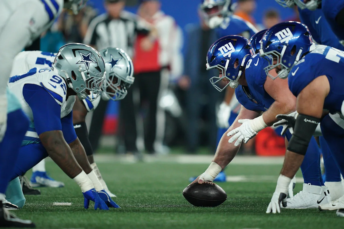Dallas Cowboys and New York Giants players line up across from each other before a snap.