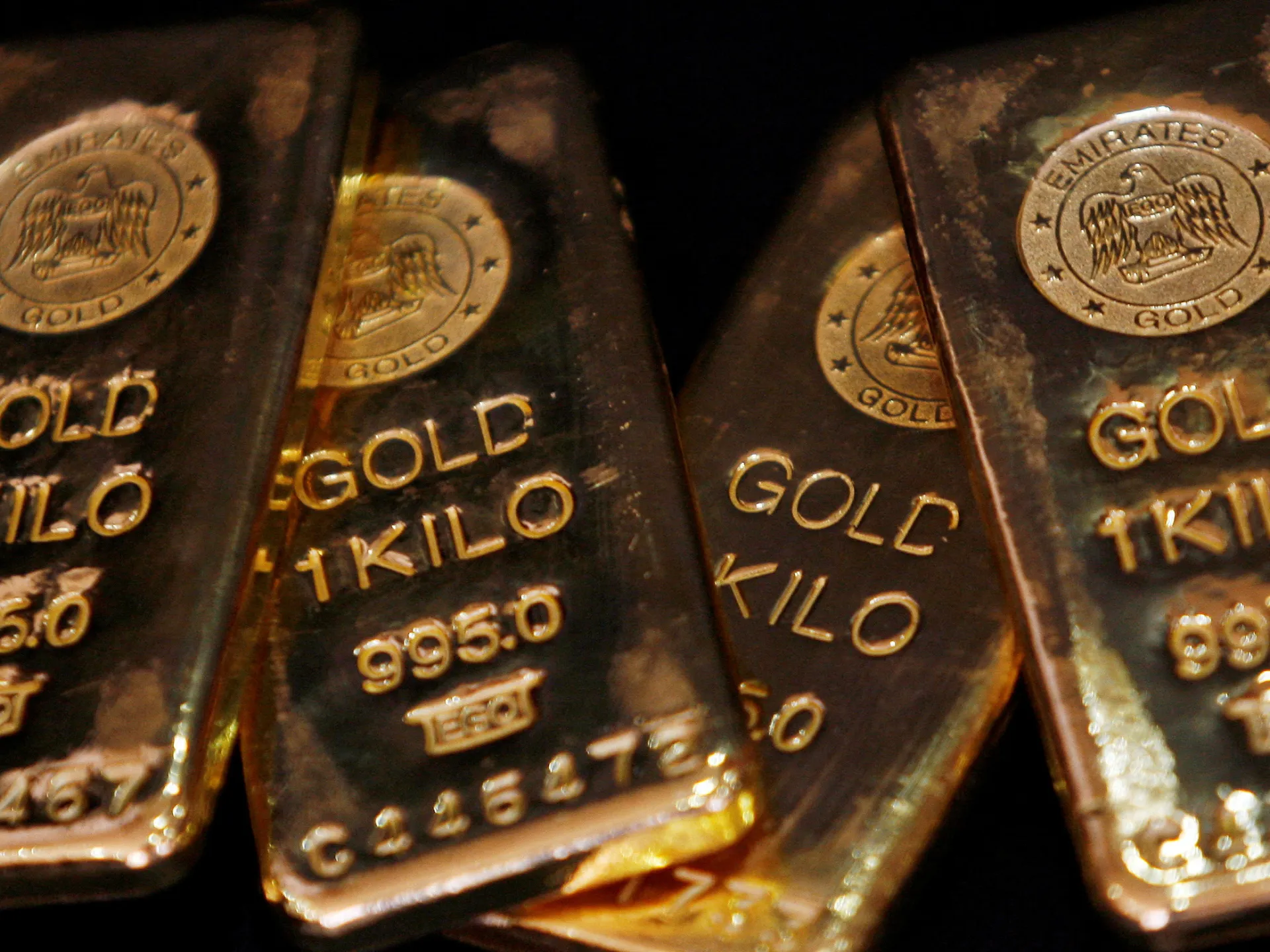 Close-up of stacked gold bars with embossed purity markings and circular eagle emblems.
