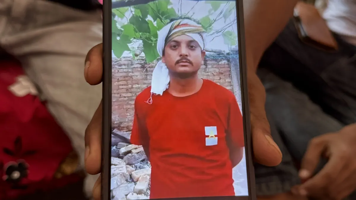 Smartphone displaying a portrait of a man in a red shirt and traditional head covering