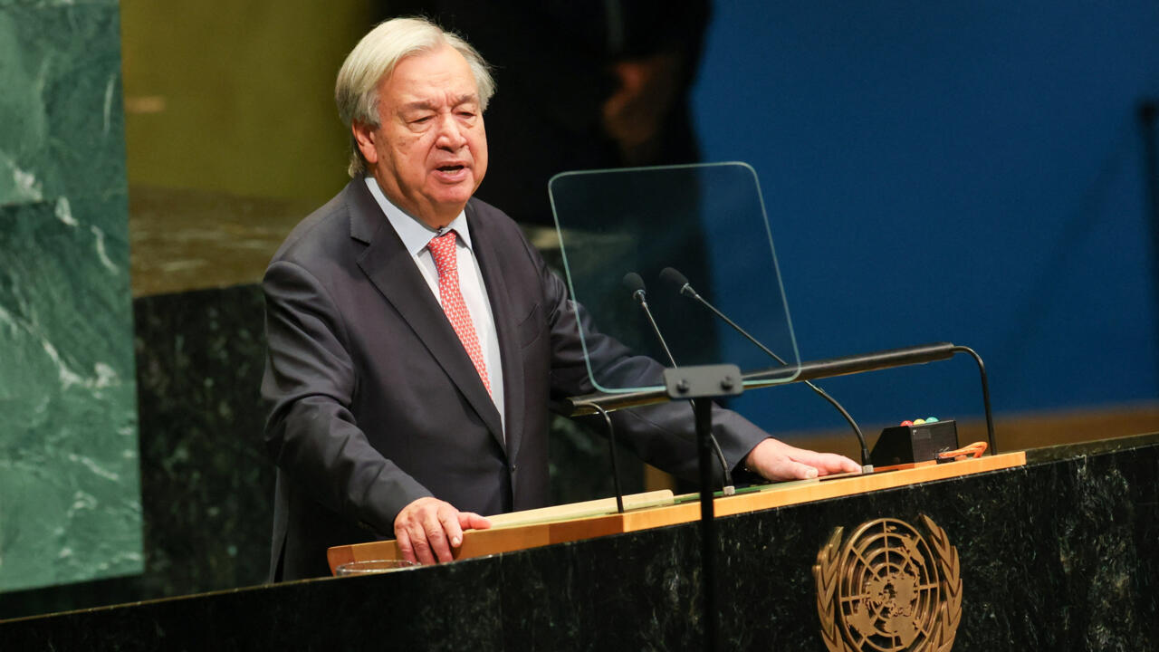 António Guterres speaks at a podium with microphones and a transparent teleprompter screen.