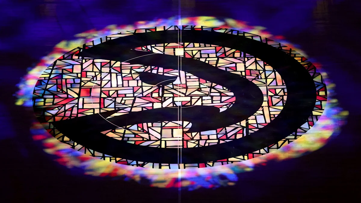 Abstract black hawk silhouette over a colorful stained-glass circular background.