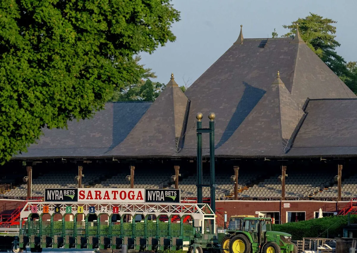 Saratoga racecourse starting gate and grandstand with a green tractor in foreground