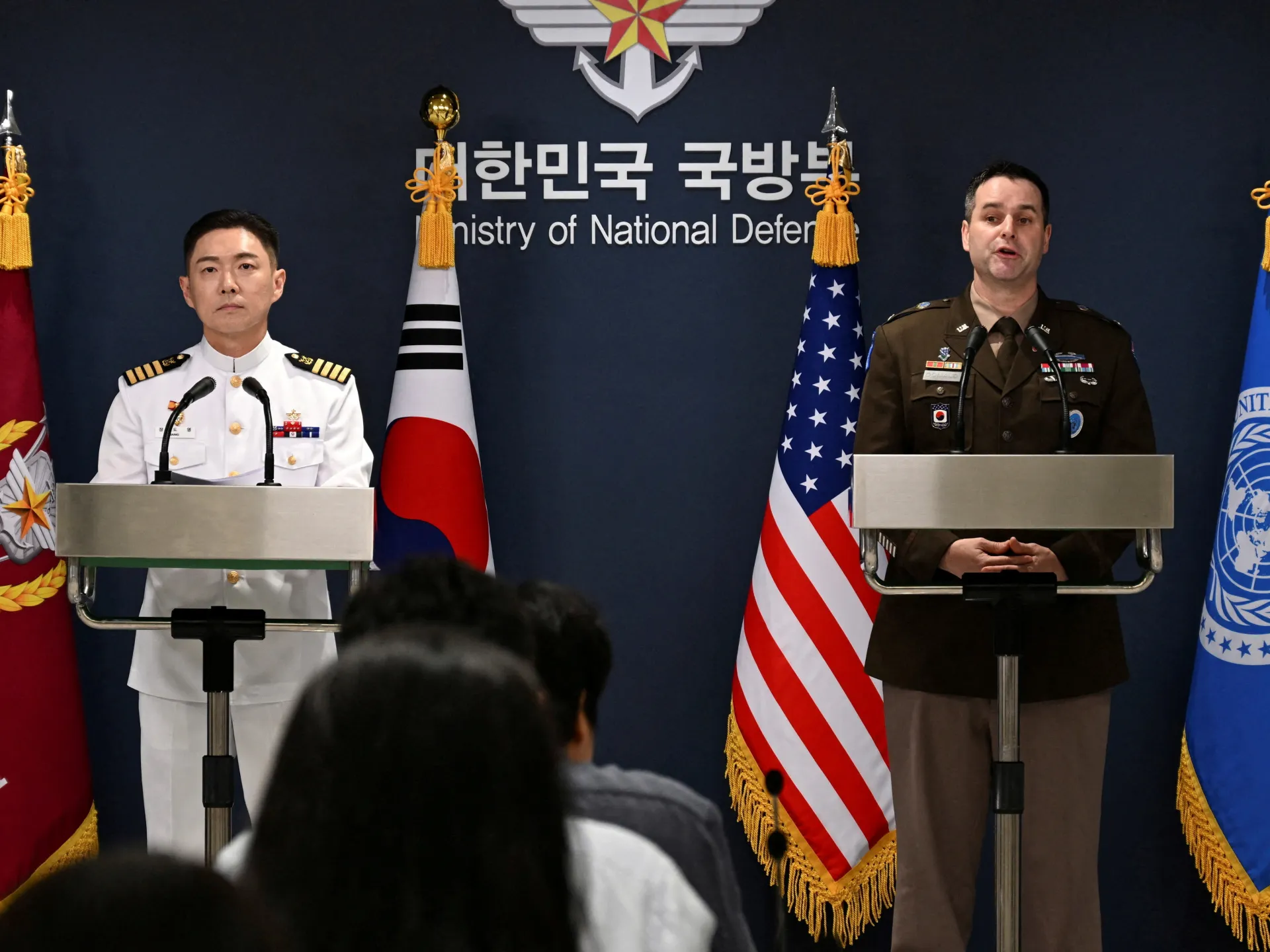 South Korean and U.S. military officials stand at podiums during a defense briefing.
