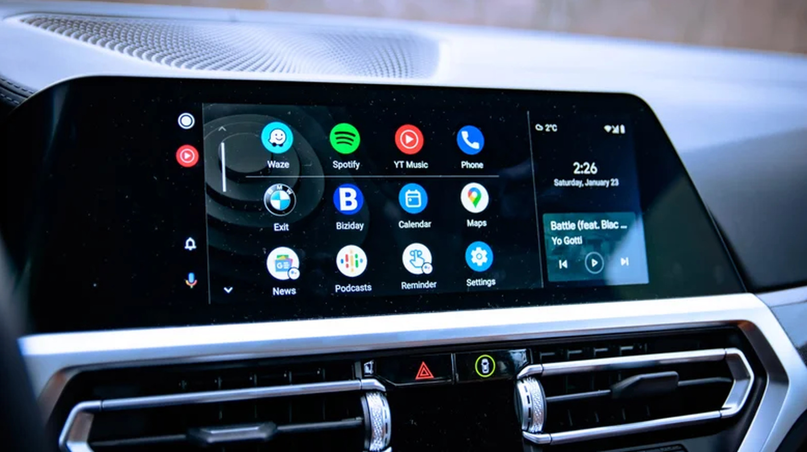 Android Auto dashboard displays app icons including Waze, Spotify, YouTube Music, phone, maps, and settings.