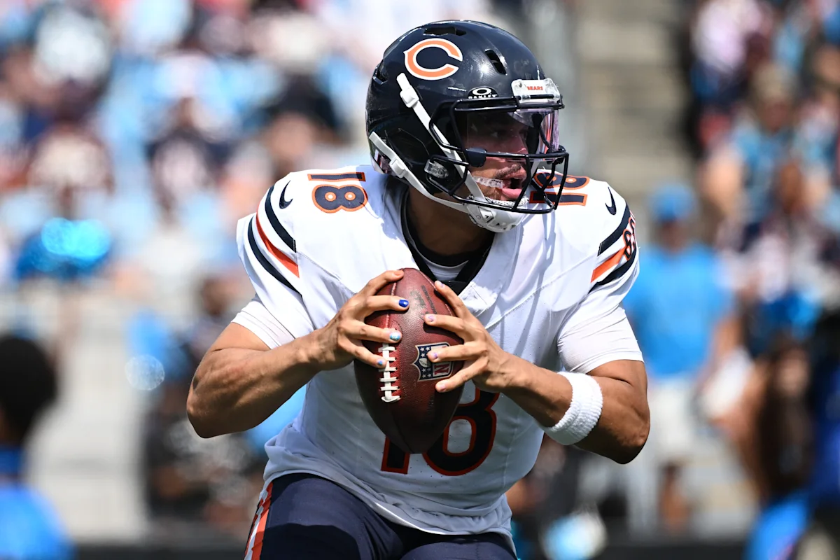 Chicago Bears quarterback in helmet grips a football during an NFL game.