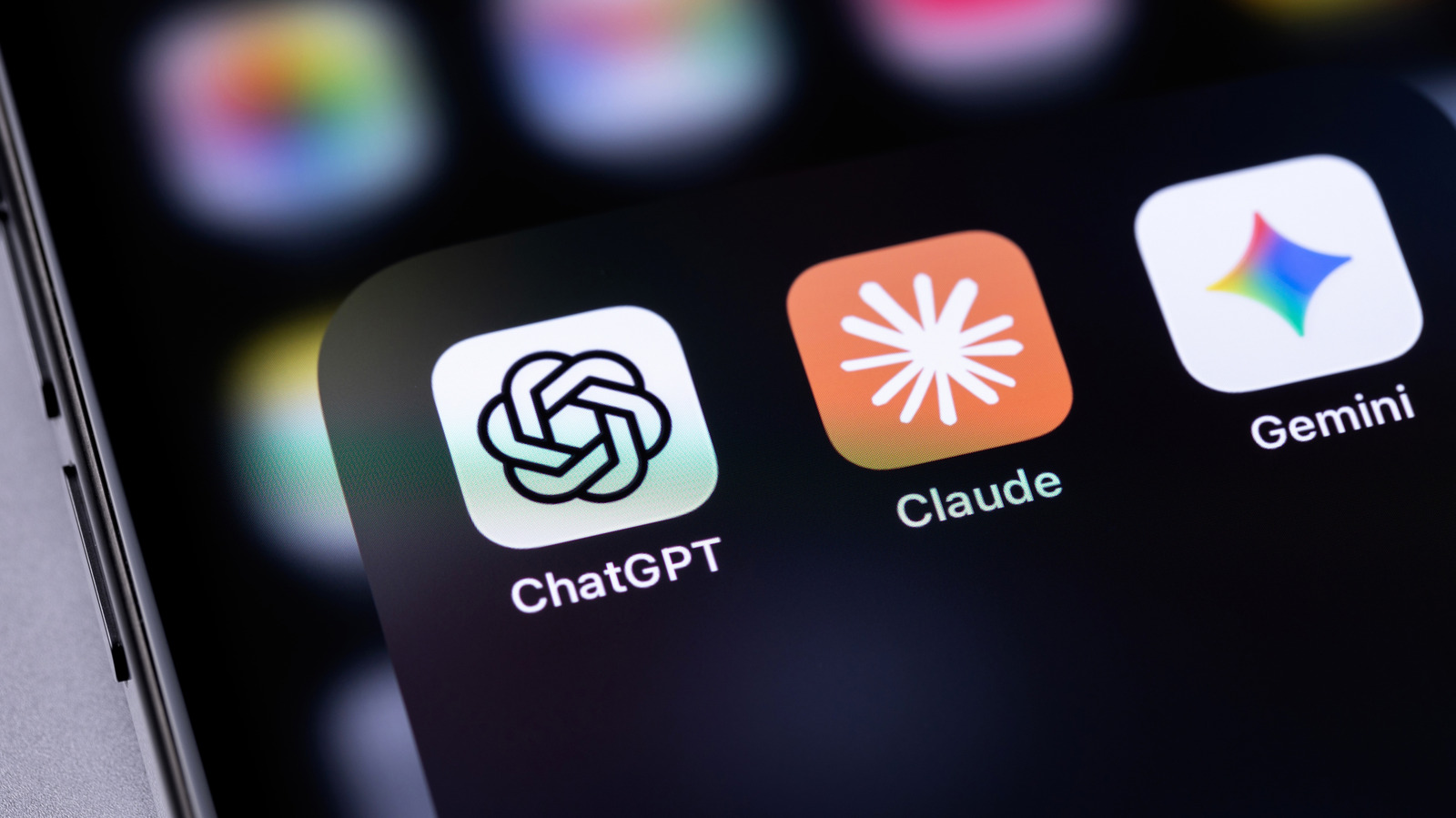 Close-up of a smartphone screen showing ChatGPT, Claude, and Gemini app icons against a dark background.