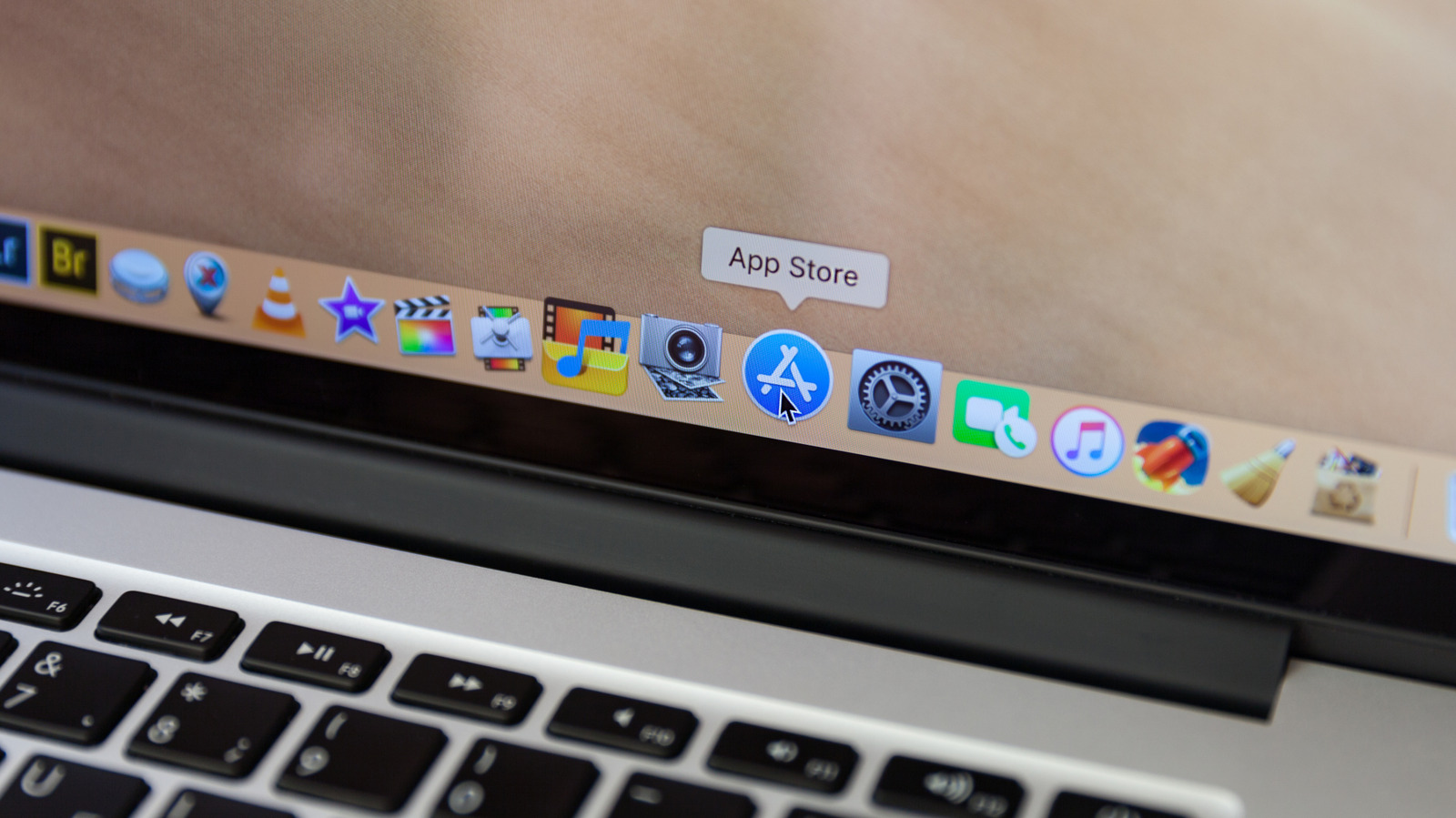 Close-up of a MacBook keyboard and screen showing the App Store icon in the Dock.