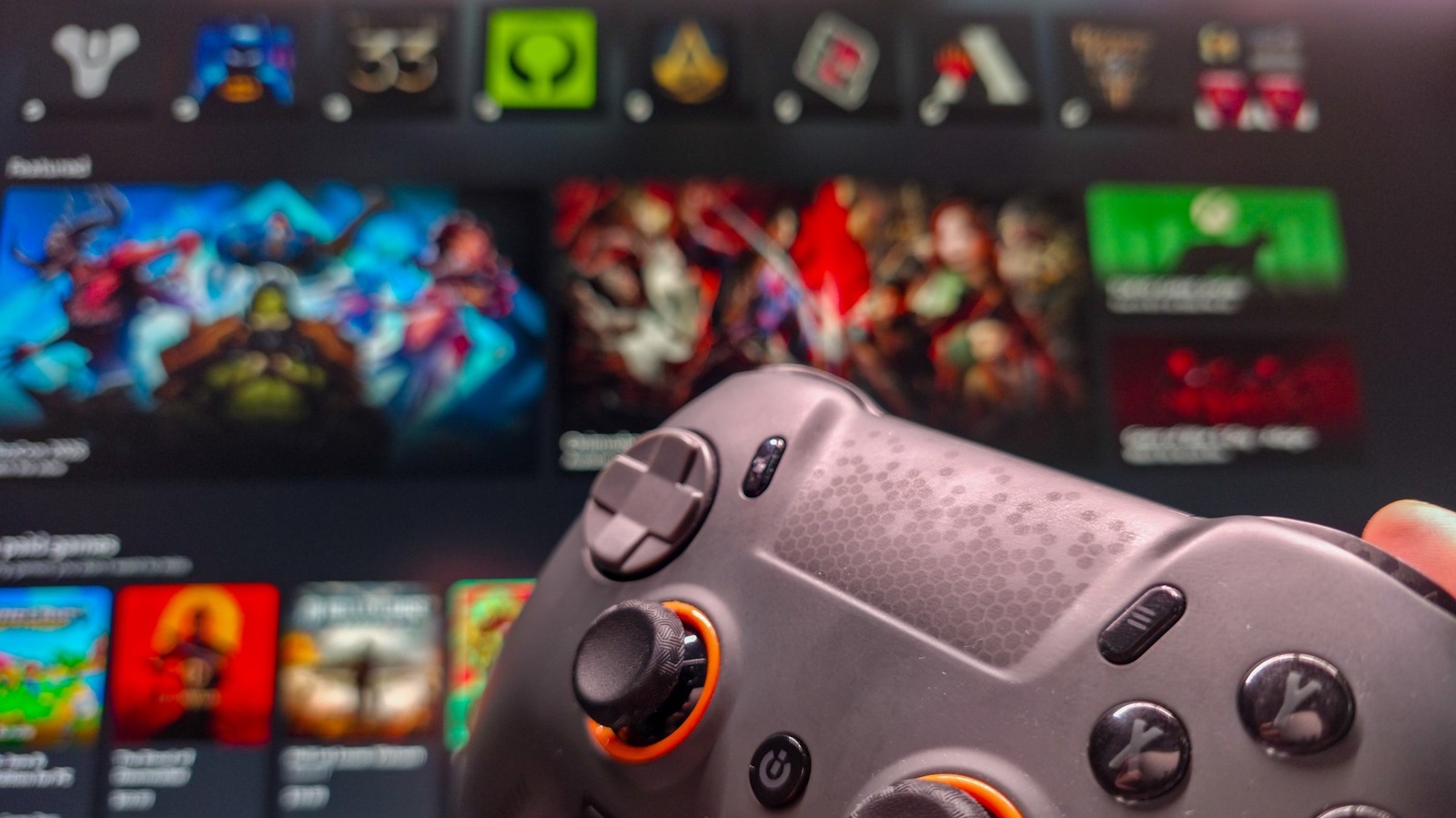 Close-up of a game controller in front of a blurred Windows PC game library