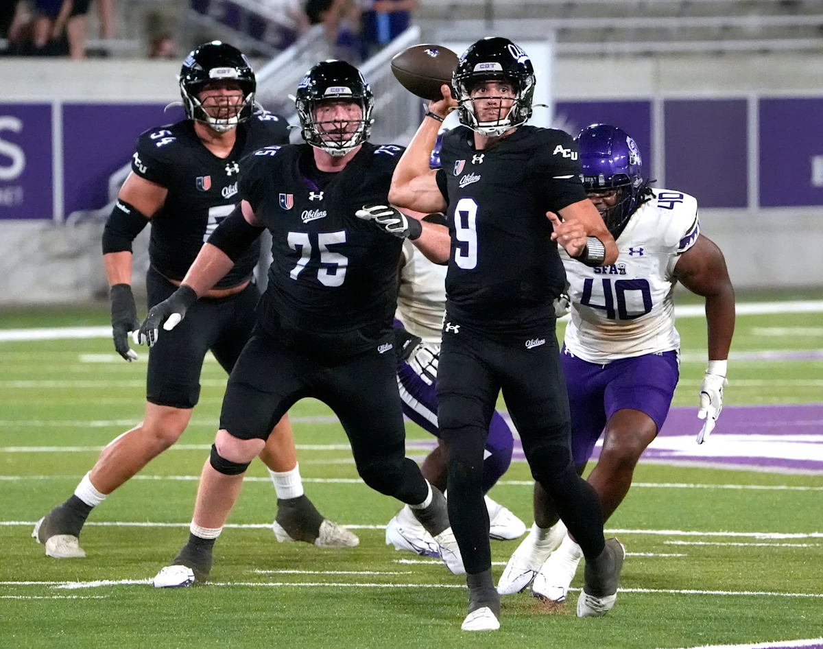 ACU quarterback throws a football as teammates block an Idaho defender during a game