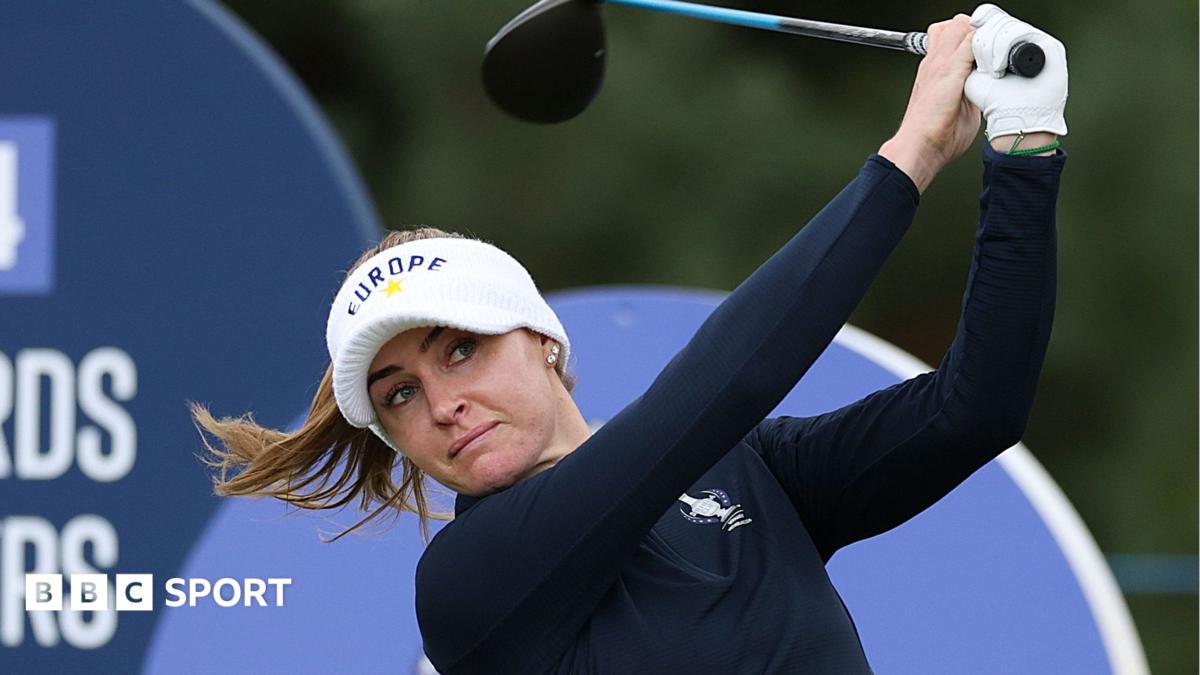 Female golfer in Europe visor swings club during a televised golf event