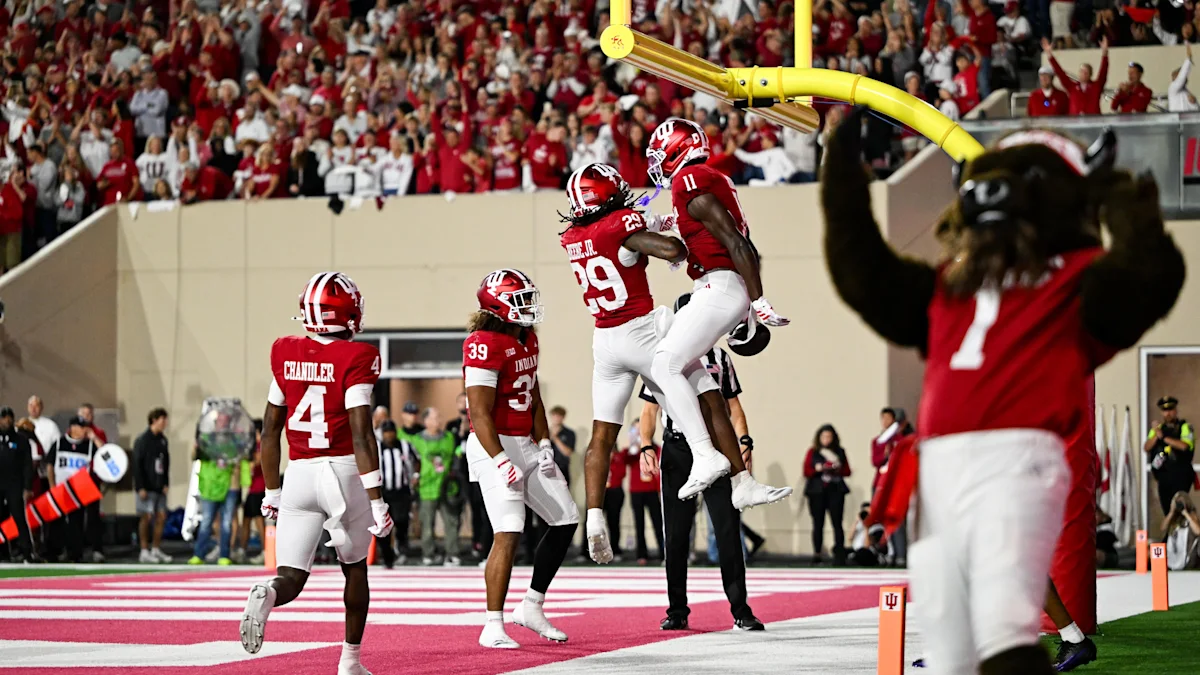 Indiana players celebrate beneath the goalpost as a teammate watches in the end zone.