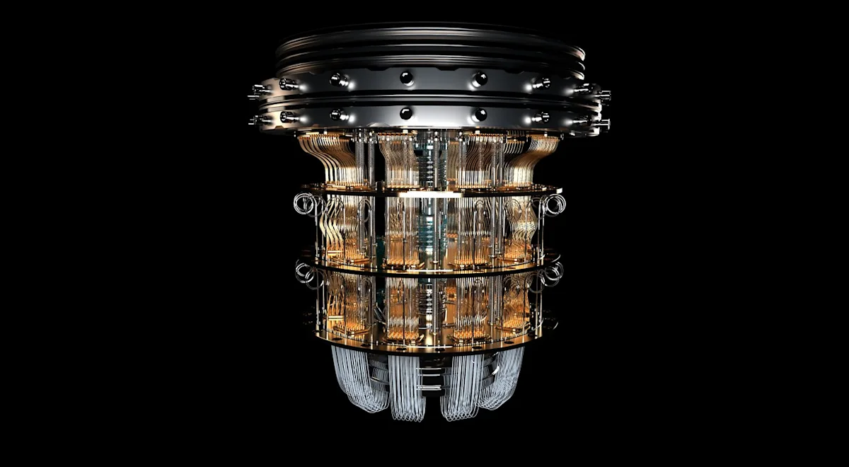Close-up of a cylindrical quantum computing device with layered metallic rings and intricate gold wiring.